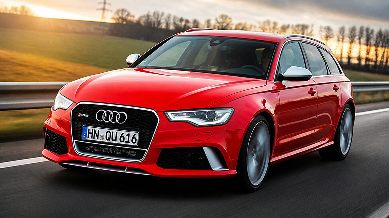 Roter Audi RS6 Kombi fährt bei Sonnenuntergang auf einer Landstraße in Deutschland.