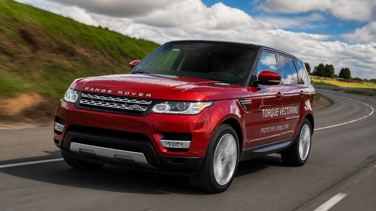 Roter Range Rover SUV fährt auf kurviger Landstraße bei bewölktem Himmel.