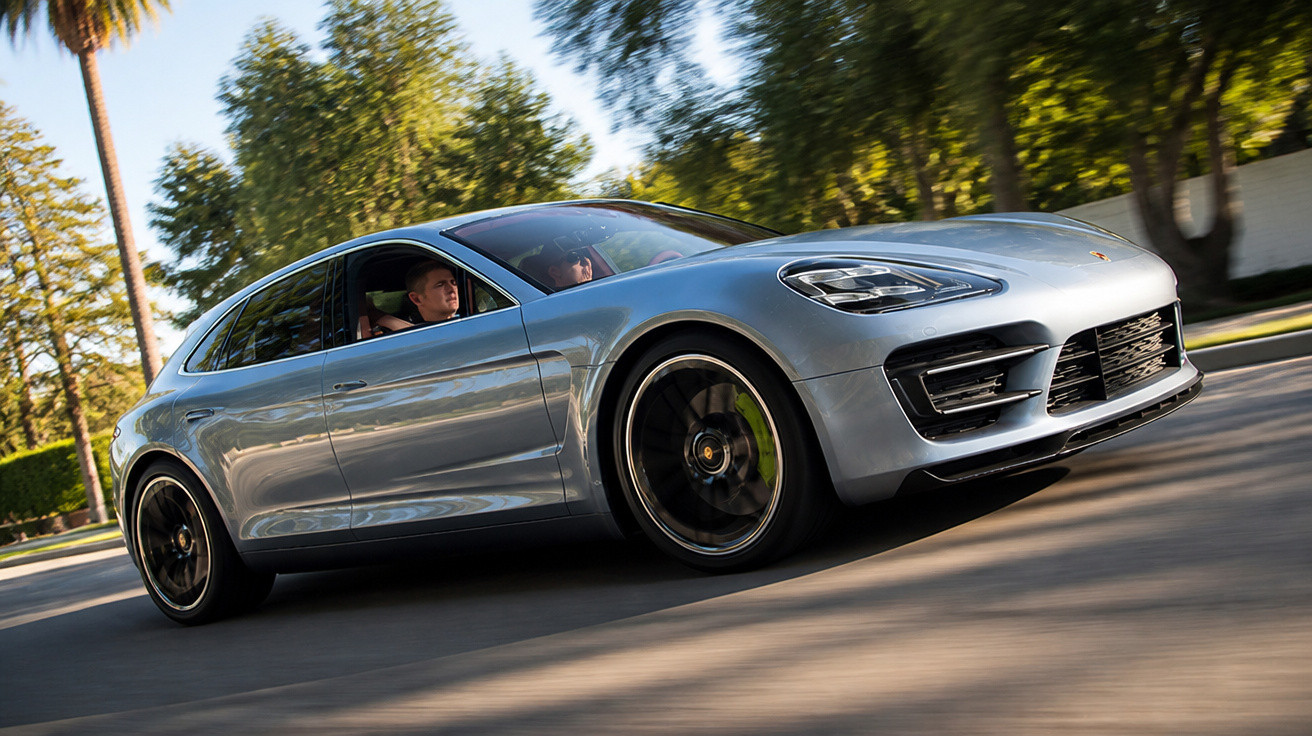 Silberner Porsche Panamera fährt mit zwei Personen auf Straße, umgeben von Bäumen und Sonnenschein.